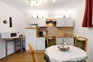 a small kitchen with white cabinets and a table with chairs at Julia's Ferienwohnung in Gallin