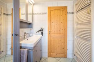 a bathroom with a sink and a wooden door at Ferienwohnung Krempermoor 1 in Krempermoor +16 photos