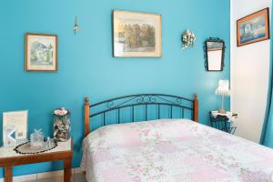 a blue bedroom with a bed and a table at The Castle House Kea in Ioulis