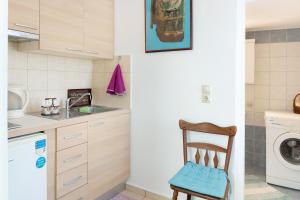 a kitchen with a washing machine and a wooden chair at The Castle House Kea in Ioulis