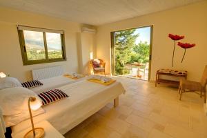 a bedroom with a large bed and a large window at Villa Kteni Ideales Resort in Kefallonia +16 photos