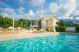 a villa with a swimming pool and a house at Villa Kteni Ideales Resort in Kefallonia