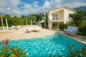 a villa with a swimming pool and a house at Villa Kteni Ideales Resort in Kefallonia