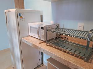 a microwave sitting on a counter next to a refrigerator at Quinta da Praia in Serra