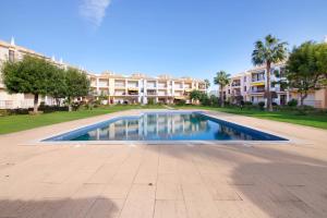 a swimming pool in front of a apartment building at Cosy Apartment with Pool 1 in Vilamoura