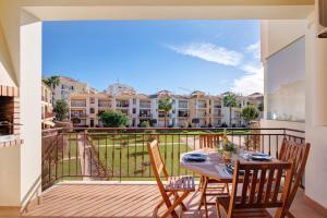 a patio with a table and chairs on a balcony at Cosy Apartment with Pool 1 in Vilamoura