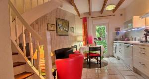 a kitchen with a table and red chairs in a room at Gites Air Marin in Lannion
