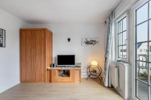 a living room with a television and a wooden cabinet at Erholung Pur in Hennstedt