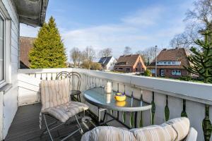a patio with a table and chairs on a balcony at Erholung Pur in Hennstedt