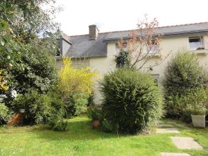a garden in front of a house with bushes at Gites Air Marin in Lannion