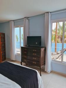 a bedroom with a bed and a dresser with a television at Quinta da Praia in Serra