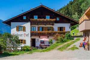 a house with a balcony with flowers on it at Lechnerhof Appartement Alpenrose in Schenna