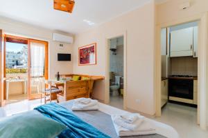 a room with a bed and a desk and a kitchen at Alice's house in Otranto