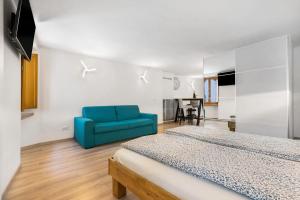 a bedroom with two beds and a blue couch at Ciarii Holiday Homes in Tremosine Sul Garda