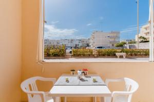 a white table and chairs in a room with a window at Alice's house in Otranto