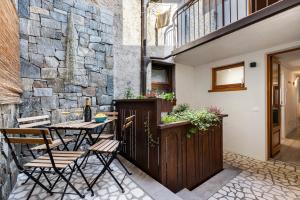 a patio with a table and chairs and a stone wall at Ciarii Holiday Homes in Tremosine Sul Garda