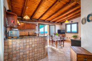 a kitchen and living room with wooden ceilings and a table at Hakéyah in Castelsardo