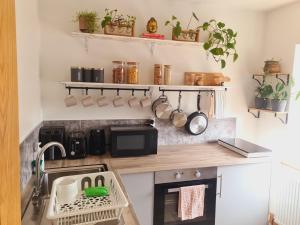a kitchen with a sink and a counter with pots and pans at Lush Rooms Bedminster in Bristol +27 photos