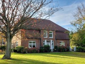 a brick house with a tree in front of it at Ferienwohnung Obenauf in Oesterwurth