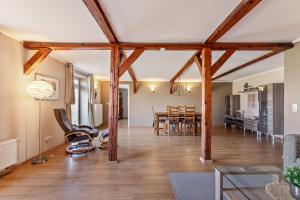 a living room and dining room with wooden beams at Ferienwohnung Obenauf in Oesterwurth