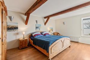 a bedroom with a bed and a wooden floor at Ferienwohnung Obenauf in Oesterwurth