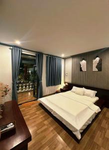 a bedroom with a large white bed and a table at Sam's homestay in Ấp Bình Hưng