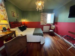 ein Schlafzimmer mit Bett, Schreibtisch und Kronleuchter in der Unterkunft Hotel Mi Norte in Ribadeo
