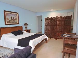 a bedroom with a bed and a table and a desk at Quinta da Praia in Serra