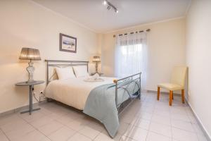 a bedroom with a bed and a table and a chair at Cool Motion Rocha Beach T2 in Portimão