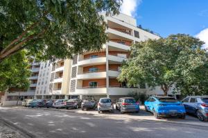 a parking lot with cars parked in front of a building at Cool Motion Rocha Beach T2 in Portimão
