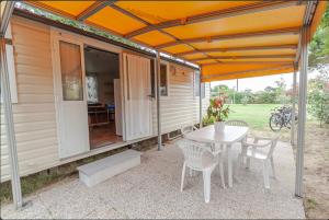 a patio with a table and chairs and a house at Agricamping Ca' Bodi Veneto in Cavallino-Treporti