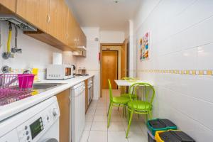 a kitchen with green chairs and a table at Cool Motion Rocha Beach T2 in Portimão
