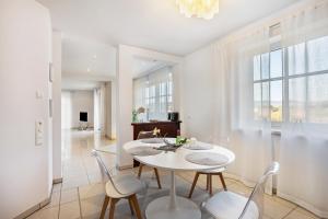 a white dining room with a white table and chairs at Fewo Schmallenberger Mauerblümchen in Schmallenberg