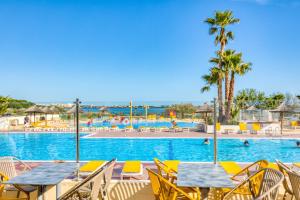 a pool at the resort with tables and chairs at Le 370 Lattes in Lattes