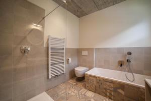a bathroom with a tub and a toilet and a shower at Apartment Das Runde in Cermes +24 photos