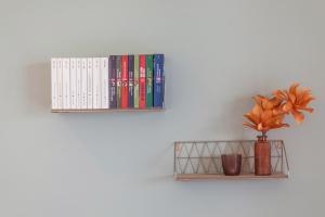 a shelf with books and a vase with a plant at Apartment Das Runde in Cermes