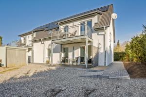 a white house with a balcony and a driveway at Ostseerauschen in Hohwacht