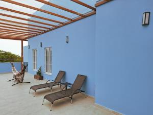 a patio with chairs and a blue wall at Quinta da Praia in Serra