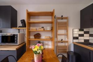 a kitchen with a table with flowers on it at Les chalets du Praz 4 - Immoclean in Morillon
