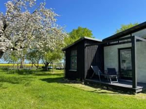 a black tiny house with a chair on the deck at Ferienwohnung Teehaus in Saal