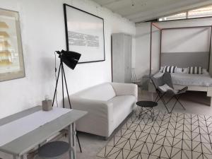 a living room with a white couch and a bed at Ferienwohnung Teehaus in Saal