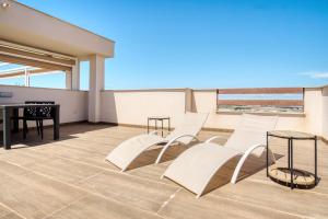 a balcony with chairs and a table and a piano at Casa Mar y Sol in Los Belones