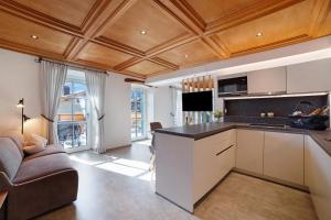 an open kitchen with a couch and a living room at Engel Appartements Goschtstub in Parcines