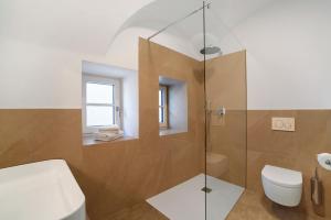 a bathroom with a toilet and a glass shower at Engel Appartements Goschtstub in Parcines +21 photos