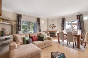 a living room with a couch and a dining room at Casa das Buganvilias in Loulé