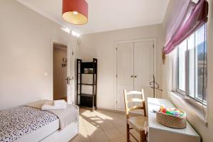 a bedroom with a bed and a desk with a chair at Casa das Buganvilias in Loulé