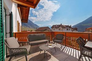 a balcony with chairs and a table and a view at Engel Appartements Goschtstub in Parcines