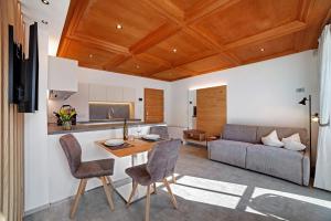 a kitchen and living room with a wooden ceiling at Engel Appartements Goschtstub in Parcines