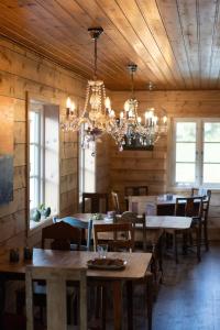 a dining room with tables and a chandelier at Aarvik organic farm & bakery in Tveit