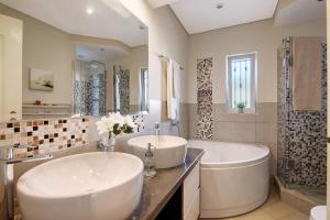 a bathroom with two sinks and a tub and a shower at Casa das Buganvilias in Loulé +22 photos